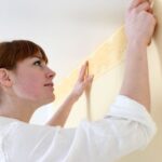 woman putting up a wallpaper border