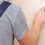 A man is making wallpaper repairs