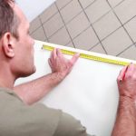 man measuring wallpaper